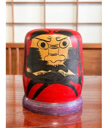 Kokeshi Daruma de Kamata Koichi sur son socle violet est présent 