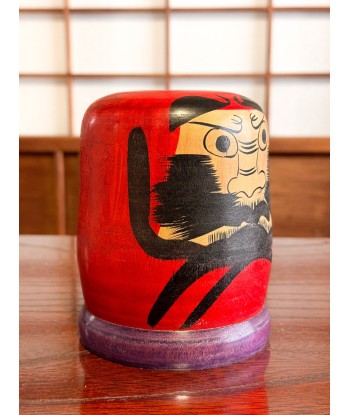 Kokeshi Daruma de Kamata Koichi sur son socle violet est présent 